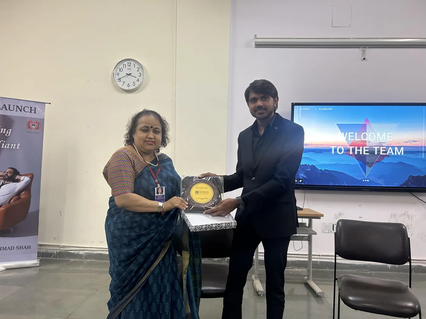Sharda University faculty presenting a memento